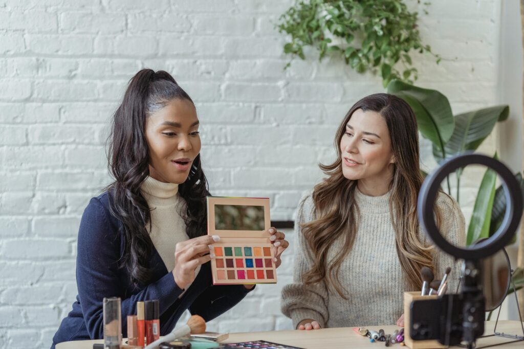 pexels-photo-6953993-6953993 Two women recording a makeup tutorial with cosmetics and equipment in a bright studio.
